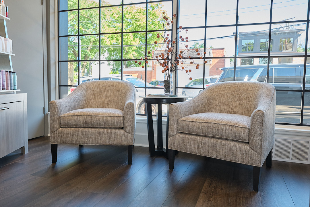 Lounge seating by the front windows at Wesley James Salon